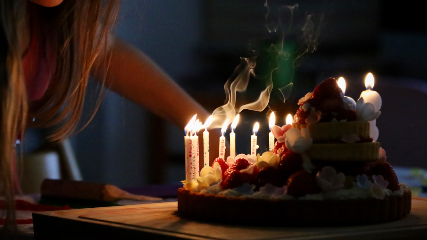 Family gathering around a celebration cake with candles